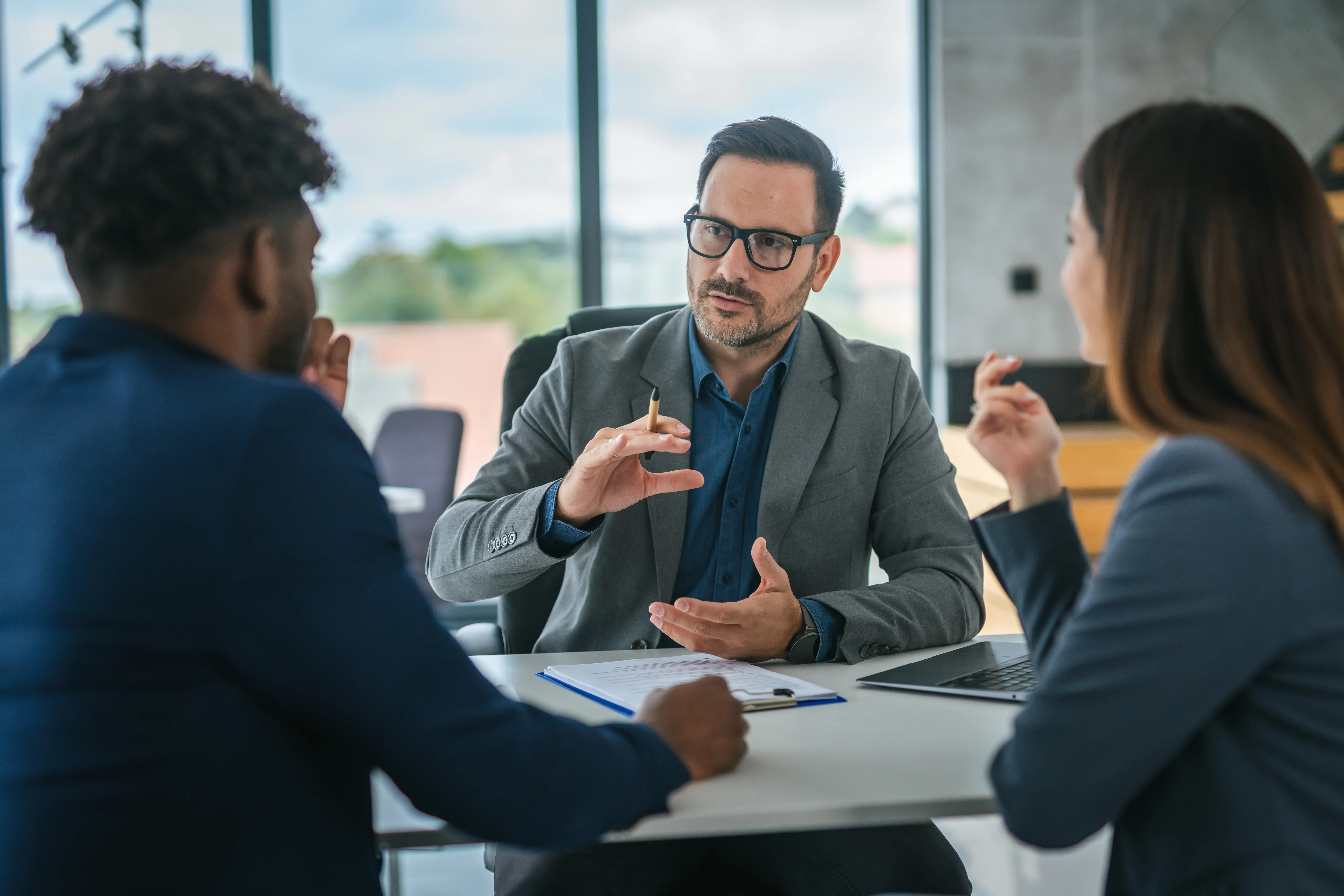 An advisor consulting with two clients at a table